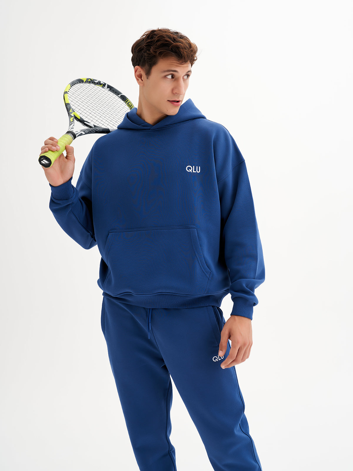 a young man holding a tennis racquet and a tennis ball