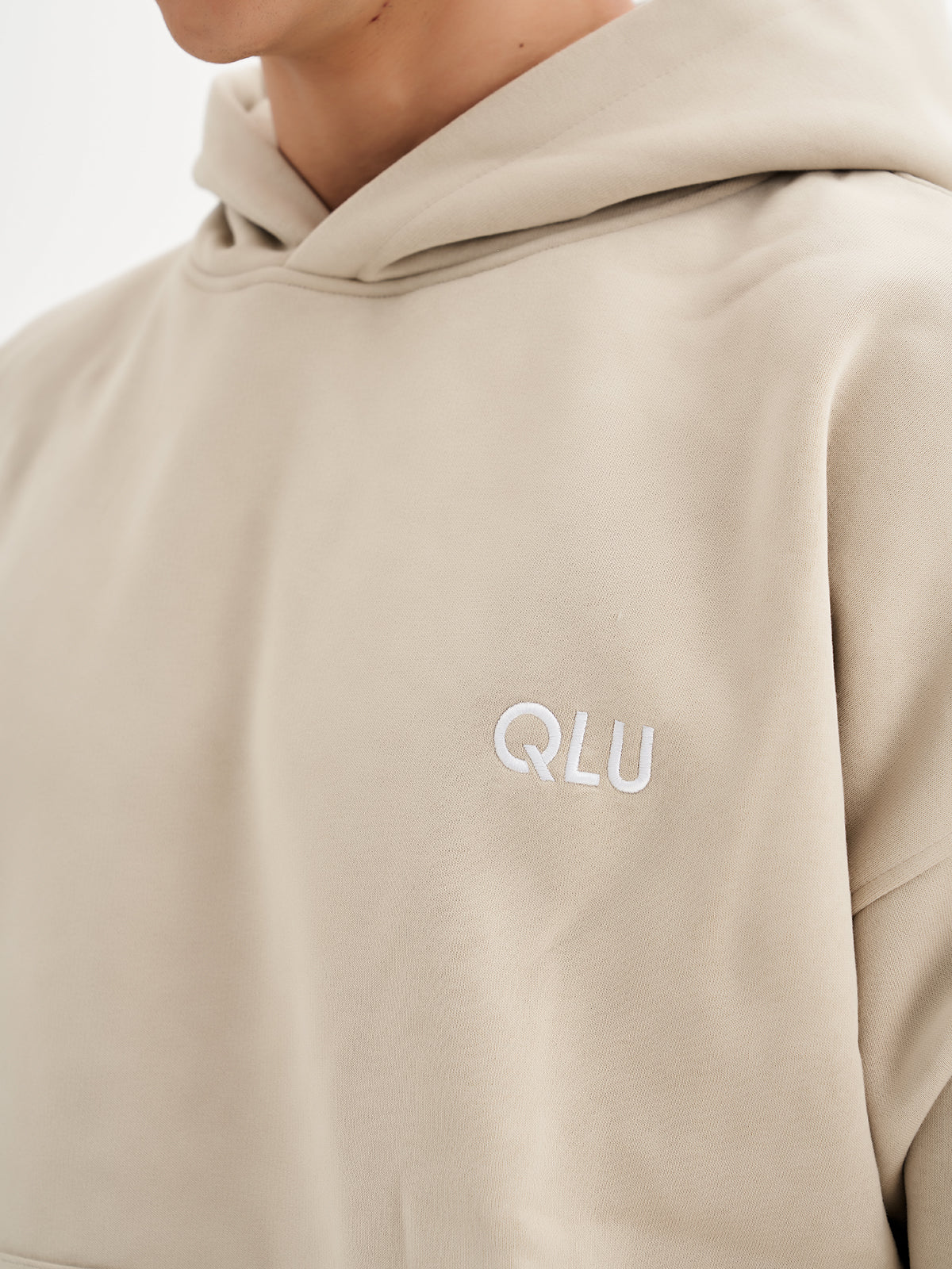 a man wearing a hoodie with the word qlu on it