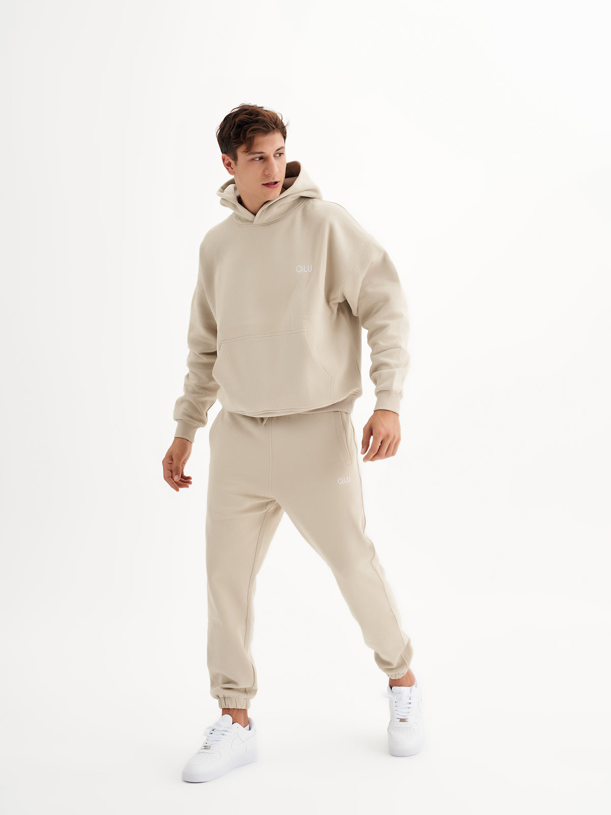 a man in a beige sweatshirt and sweat pants