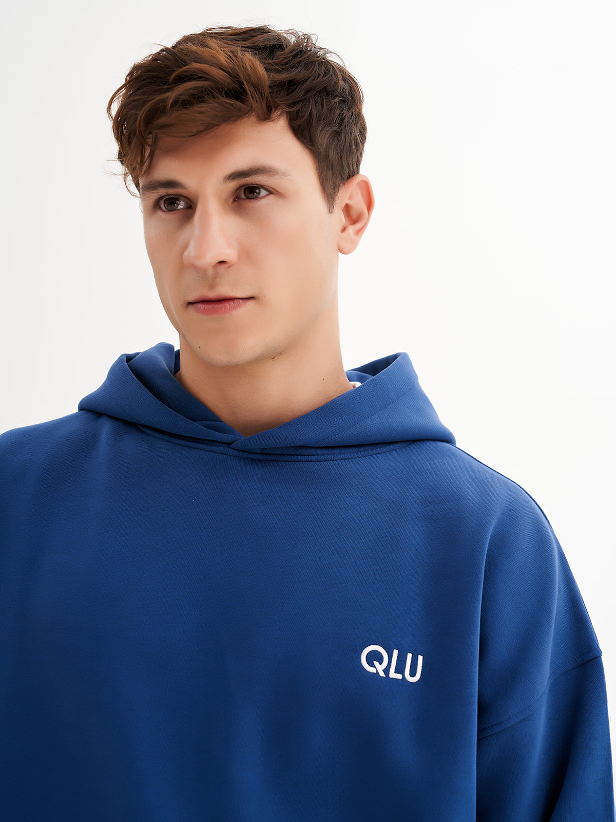 a young man in a blue hoodie poses for a picture
