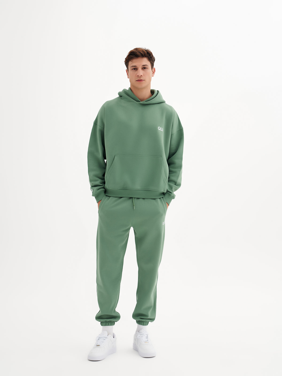 a young man in a green sweatshirt and sweatpants