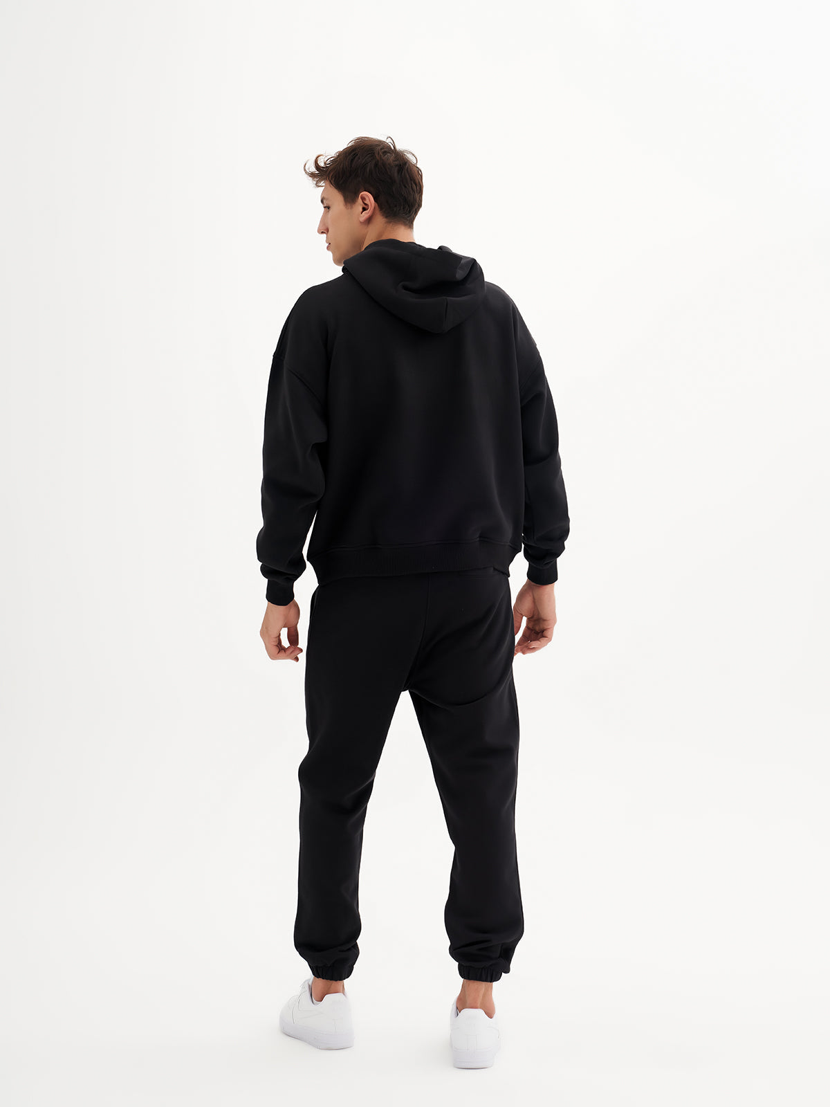 a man wearing a black hoodie and sweatpants