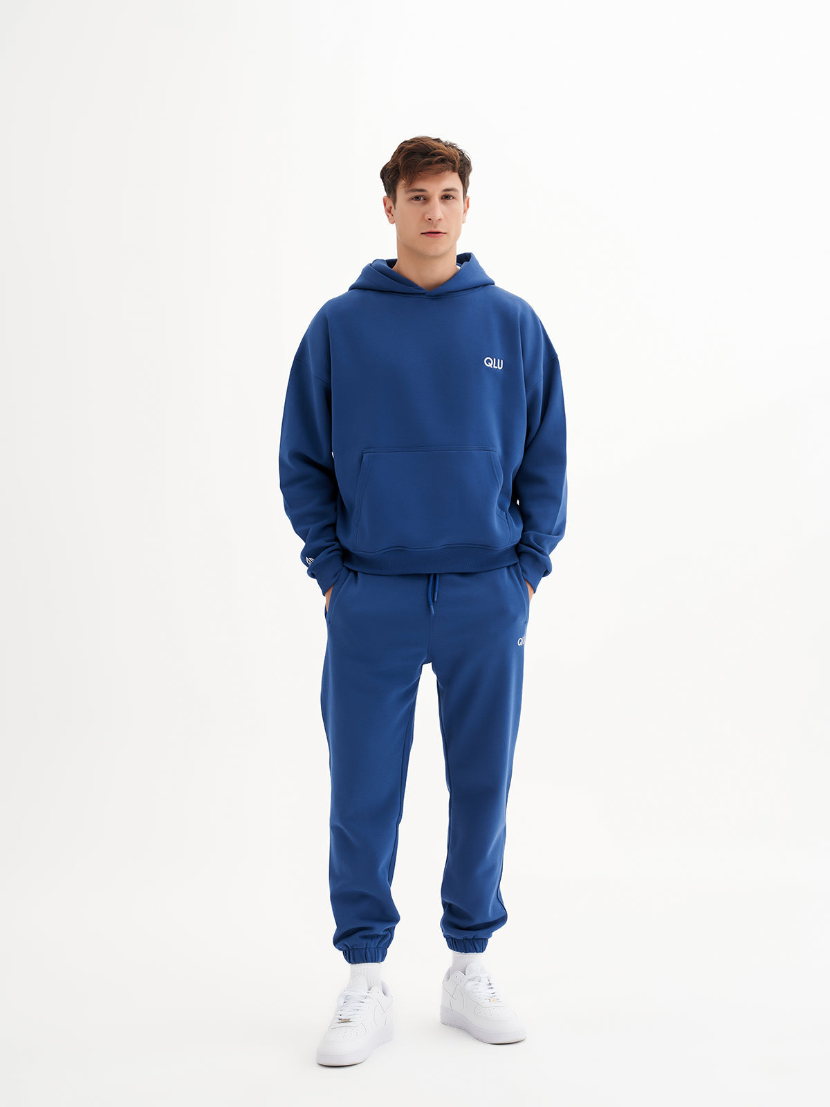 a young man wearing a blue hoodie and sweatpants