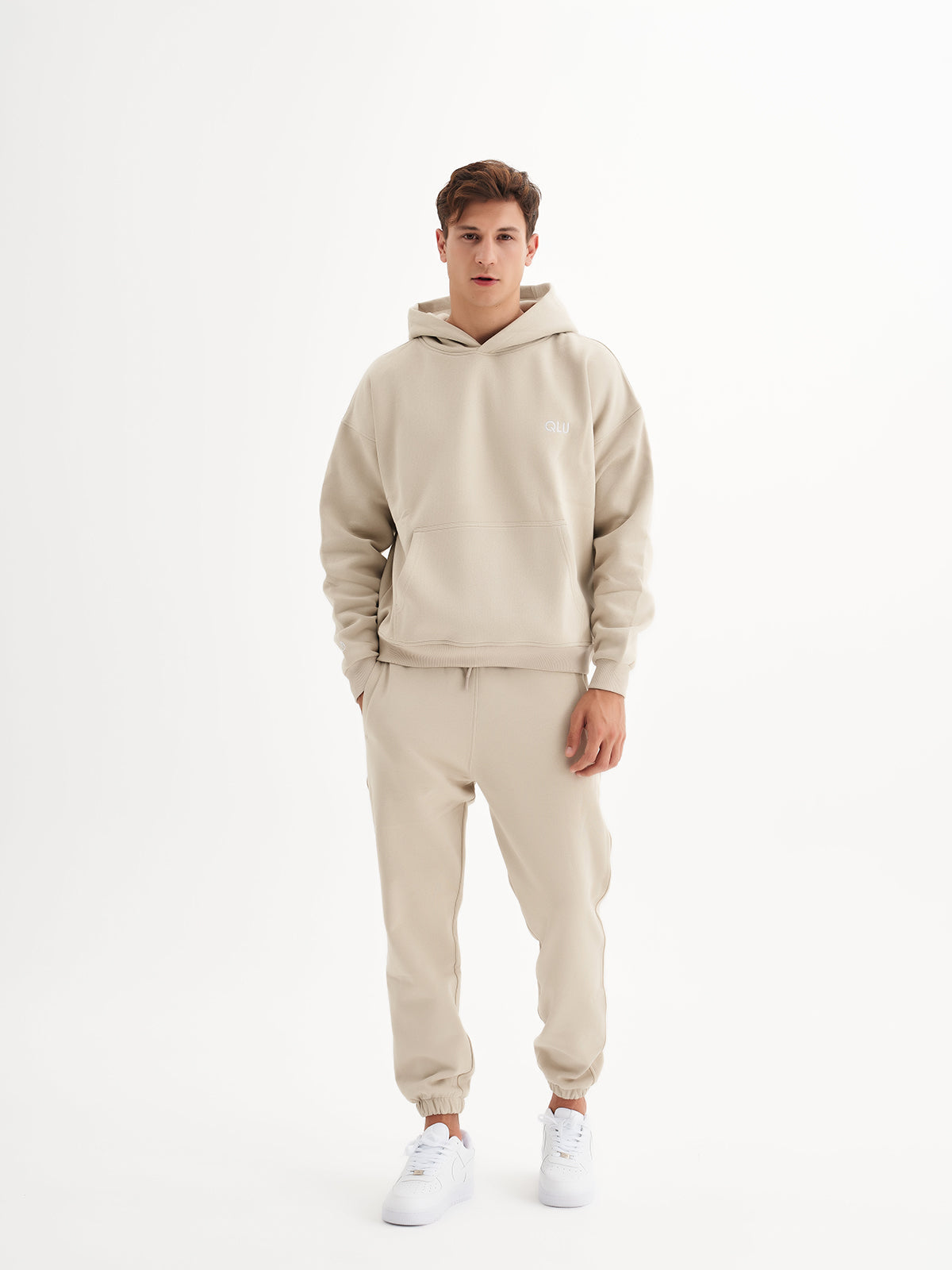 a man in a beige sweatshirt and sweatpants