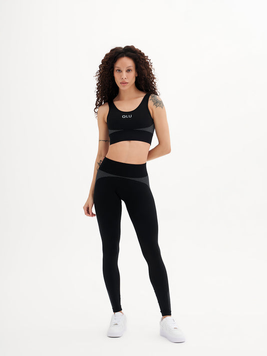 a woman in a black sports bra top and leggings