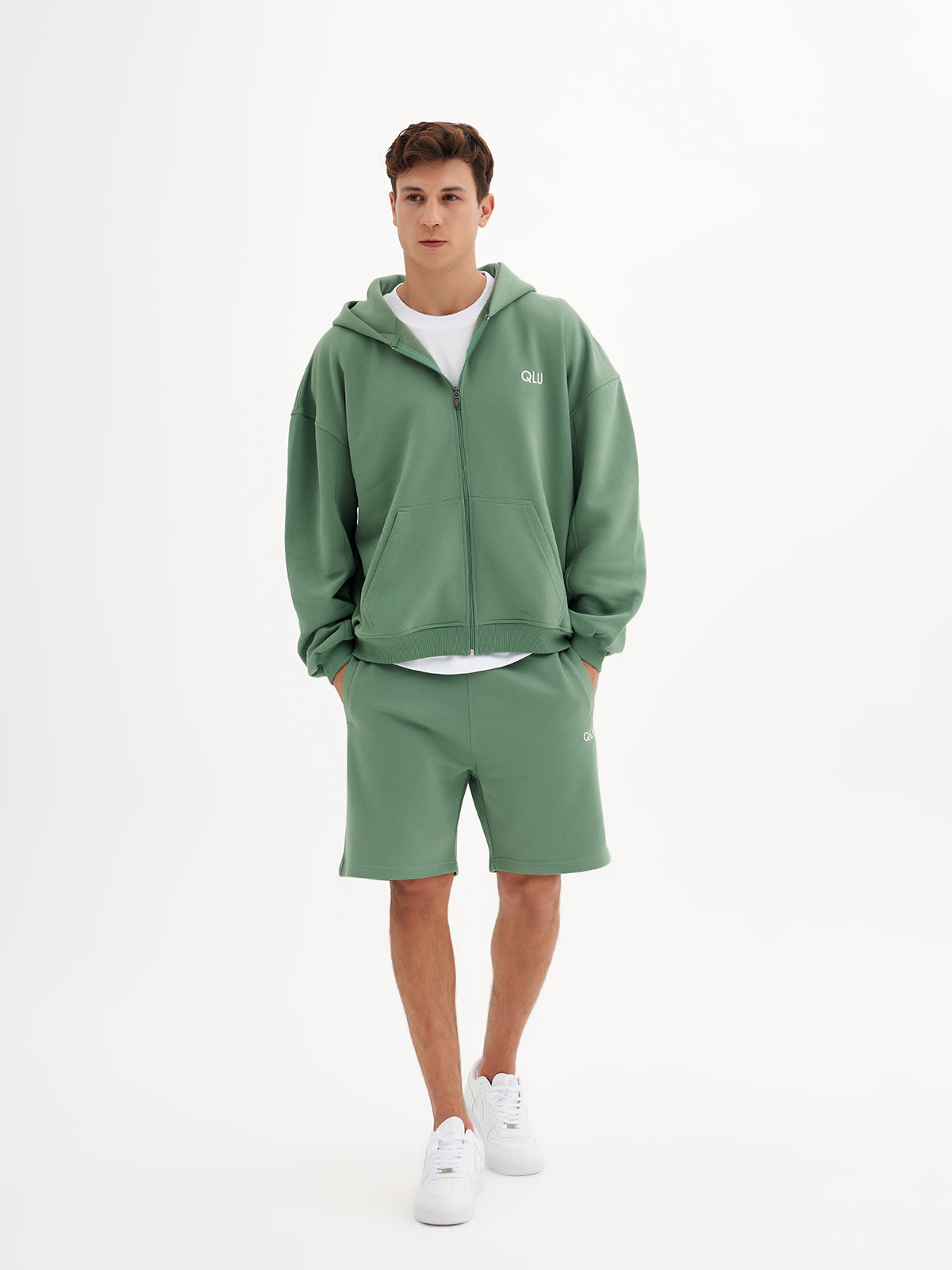 a man in a green sweatshirt and shorts