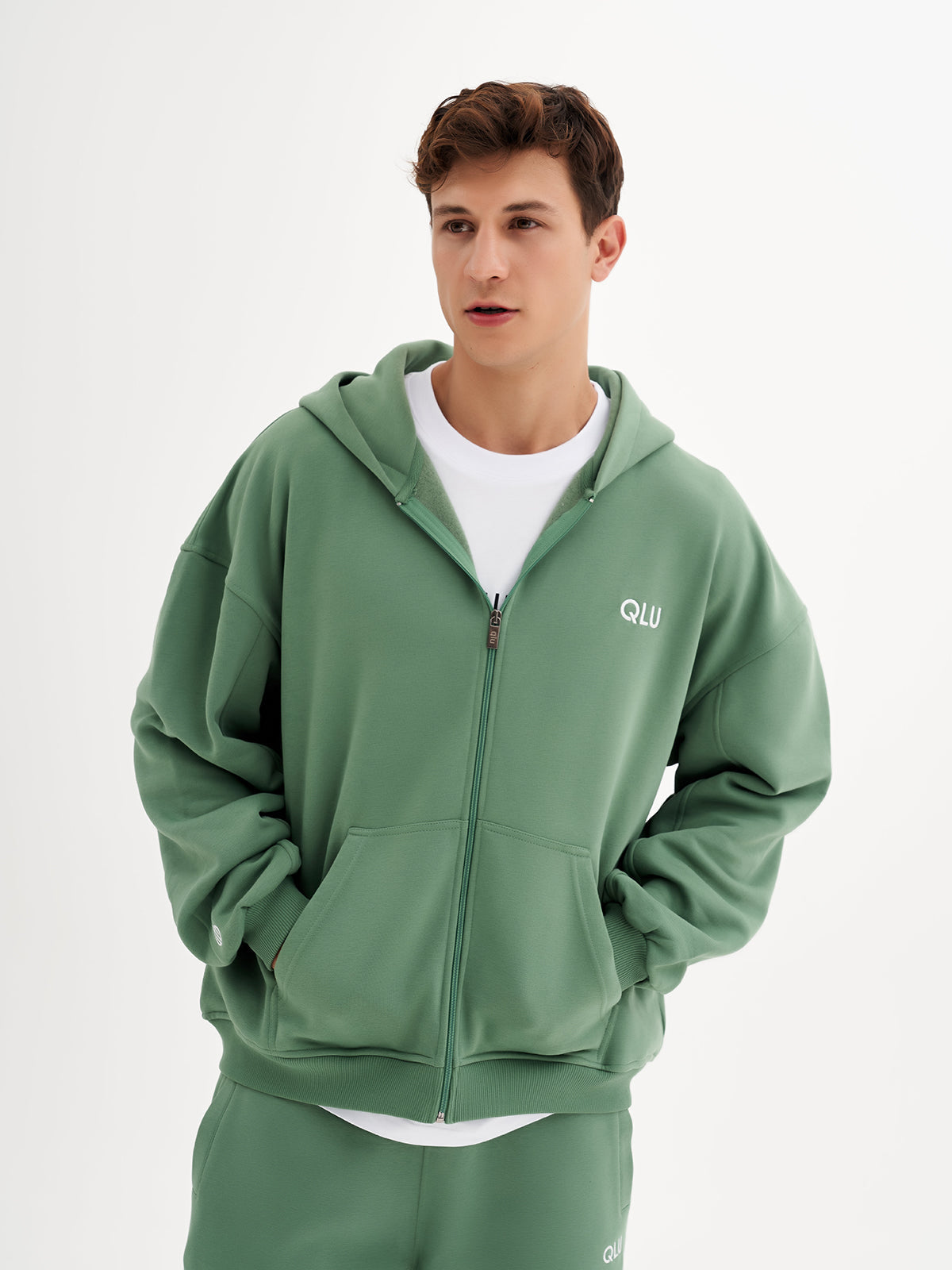 a young man in a green sweatshirt and shorts