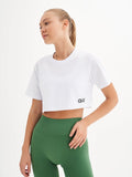 a woman in a white crop top and green leggings