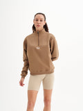 a woman wearing a brown sweatshirt and shorts