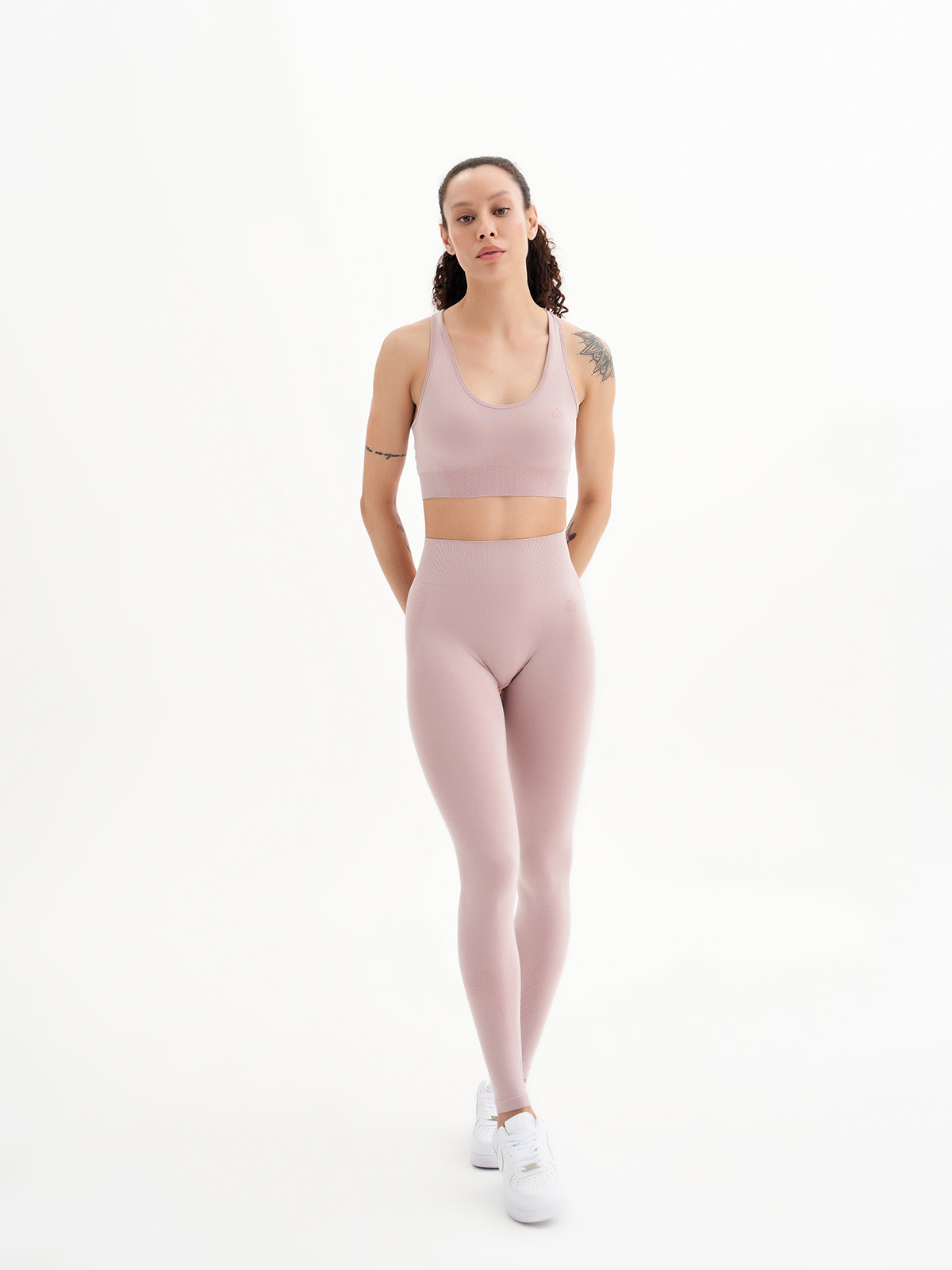 a woman in a pink sports bra top and leggings