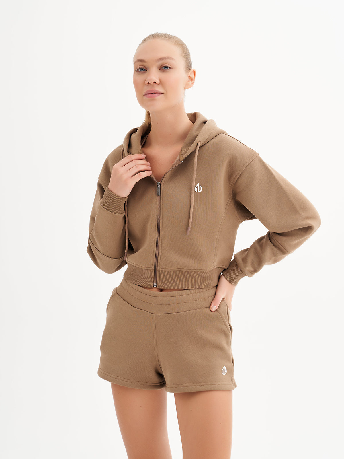 a woman wearing a brown hoodie and shorts