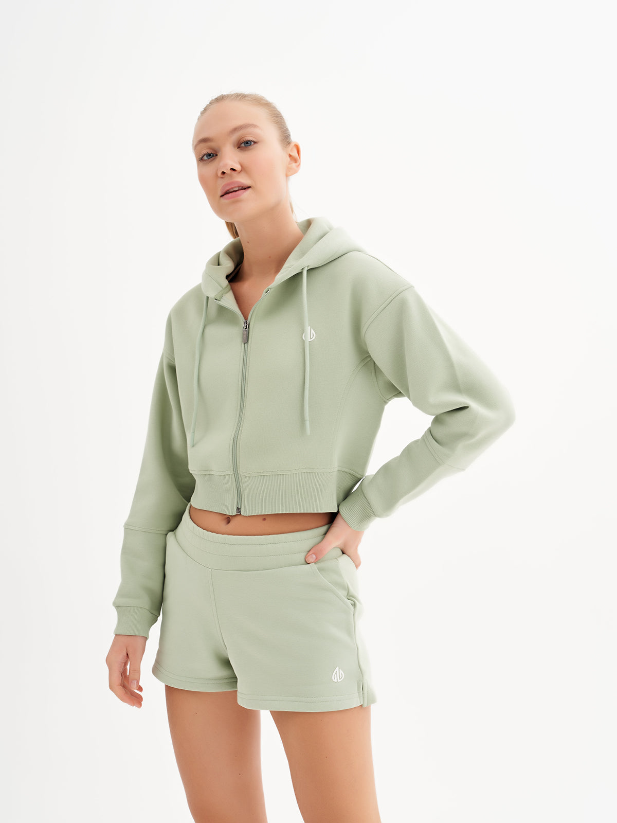 a woman in a light green sweatshirt and shorts