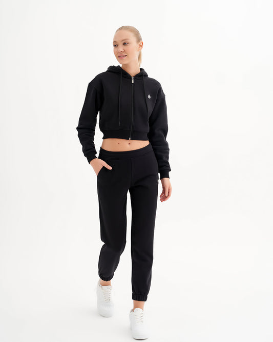 a woman in a black crop top and sweat pants
