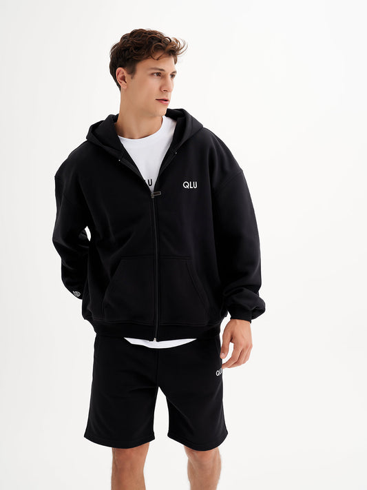 a man in a black hoodie and shorts