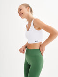 a woman in a white top and green leggings