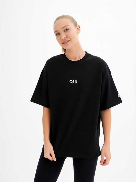 a woman wearing a black t - shirt that says ouu