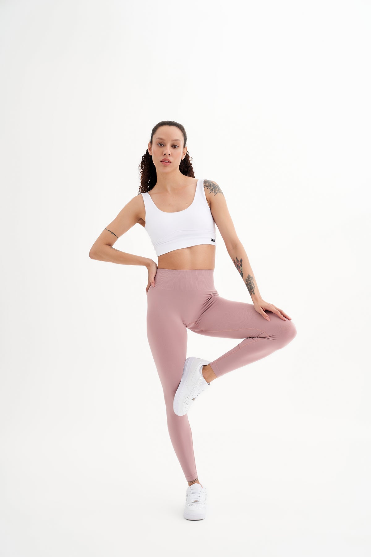 a woman in a white top and pink leggings