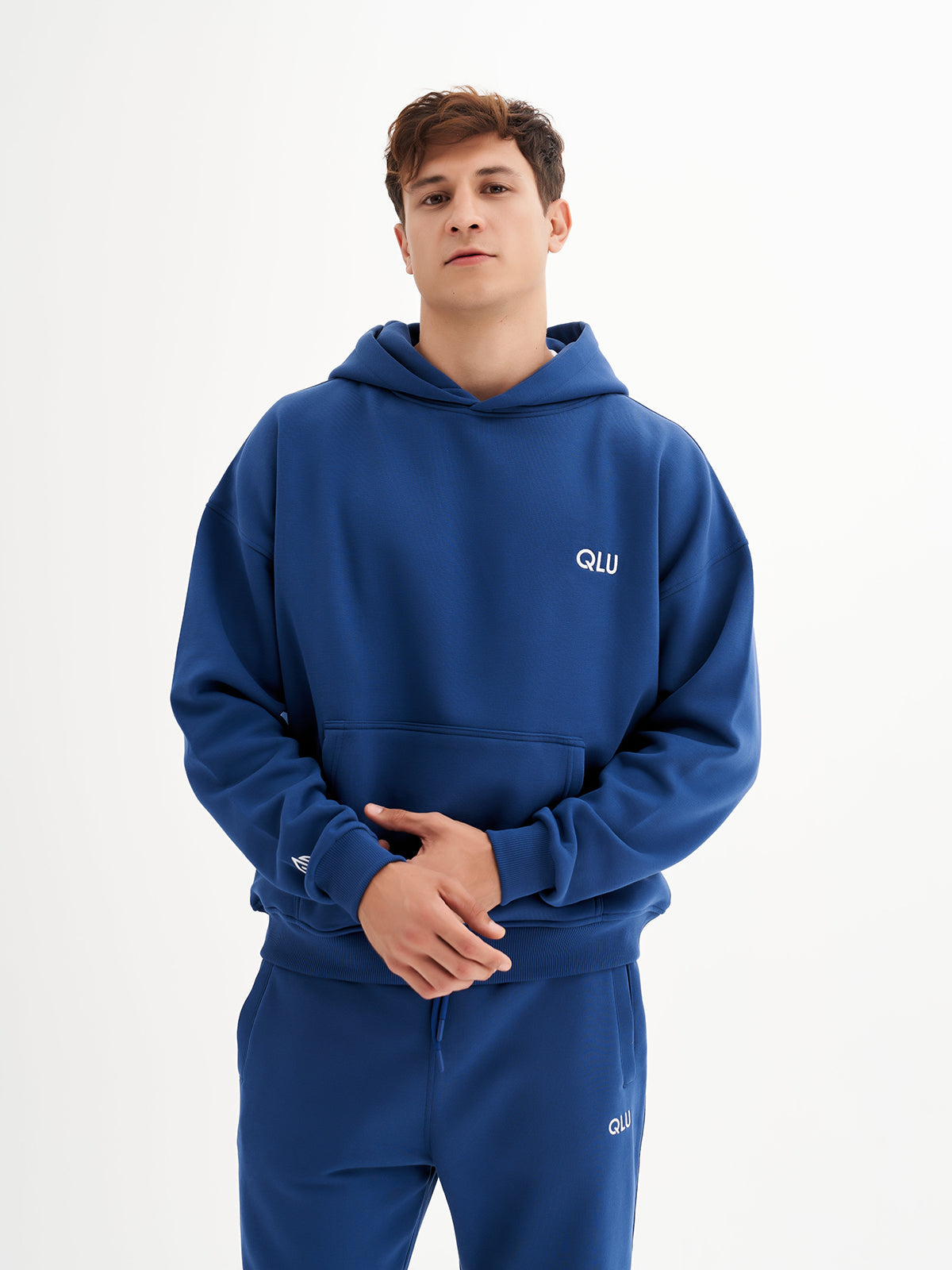 a young man in a blue hoodie poses for a picture