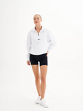 a woman in a white sweatshirt and black shorts