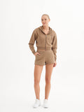 a woman in a brown hoodie and shorts