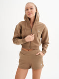 a woman wearing a brown hoodie and shorts