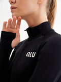 a woman wearing a black top with a white logo on it