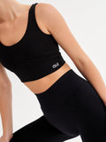 a woman in a black sports bra top and leggings