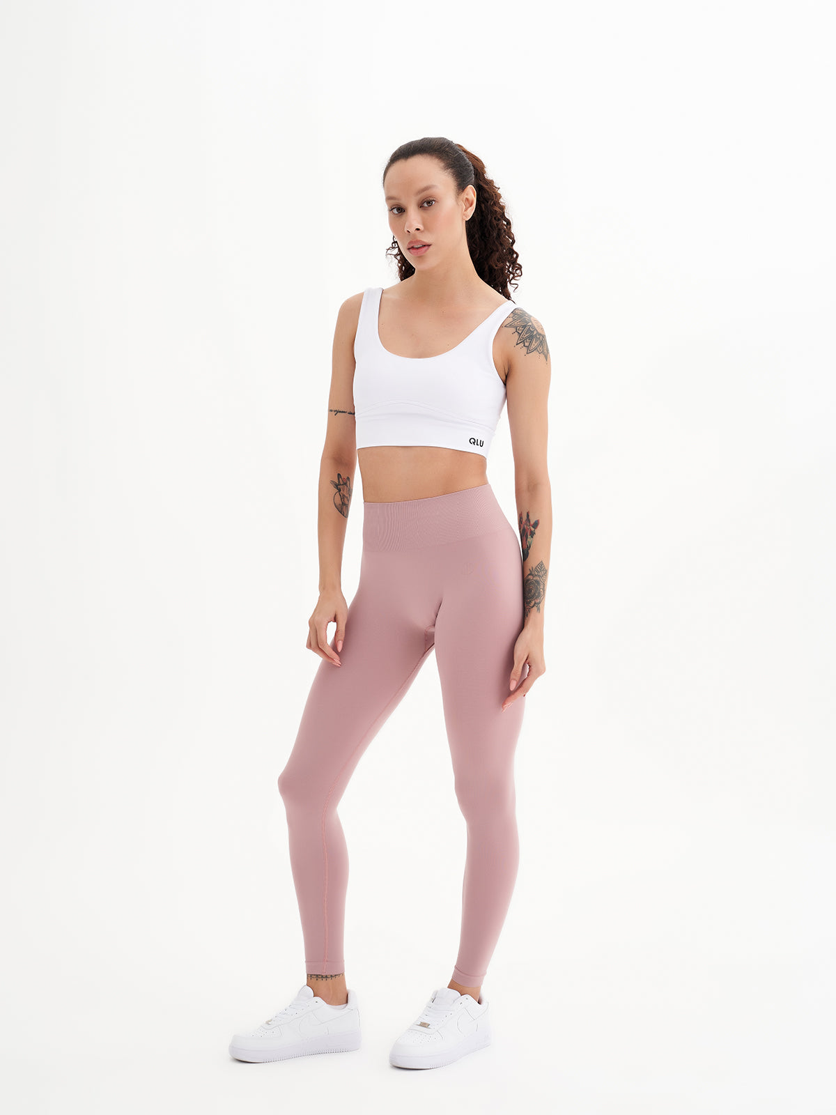 a woman in a white top and pink leggings