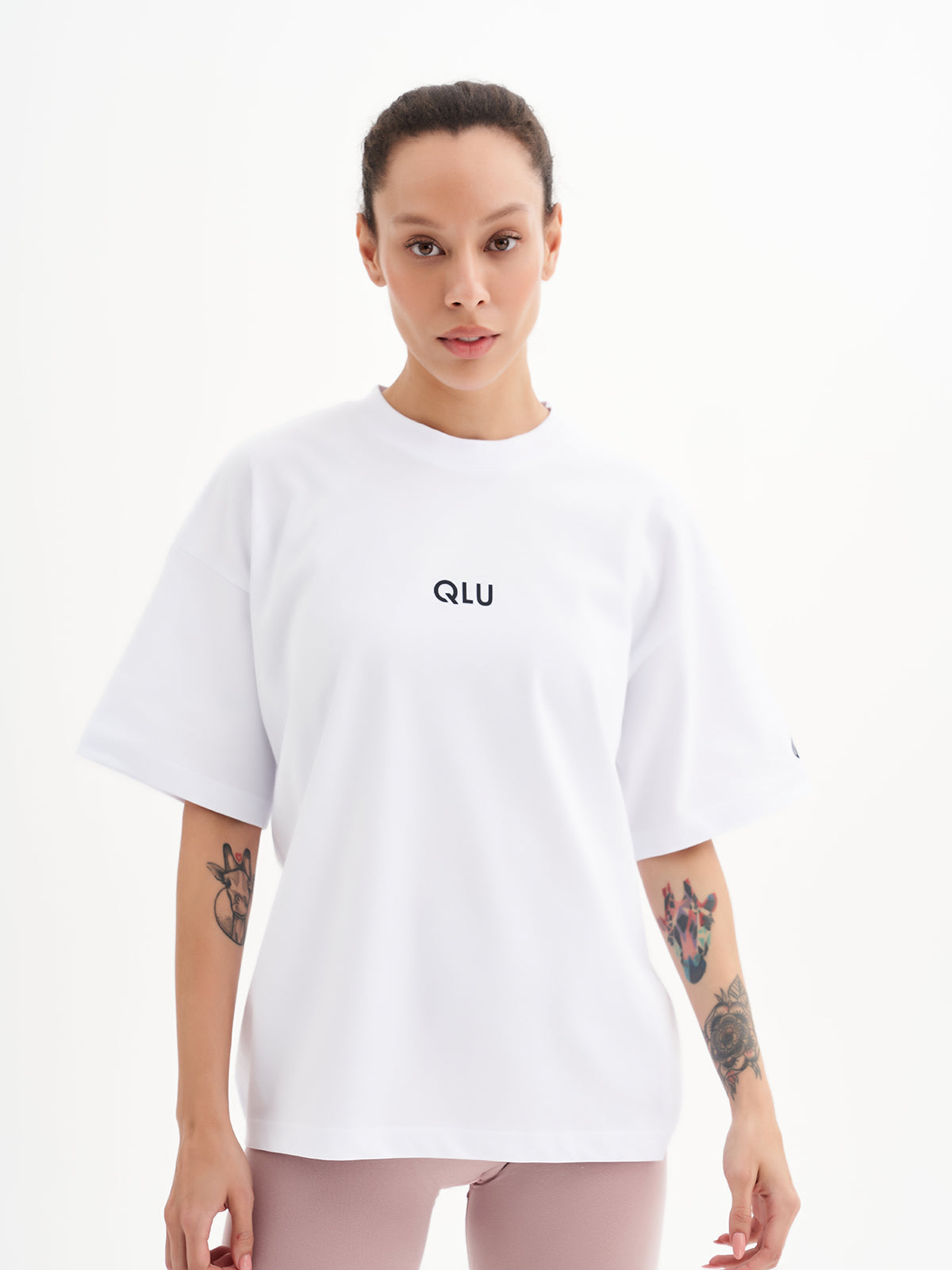 a woman wearing a white t - shirt with the word u u on it