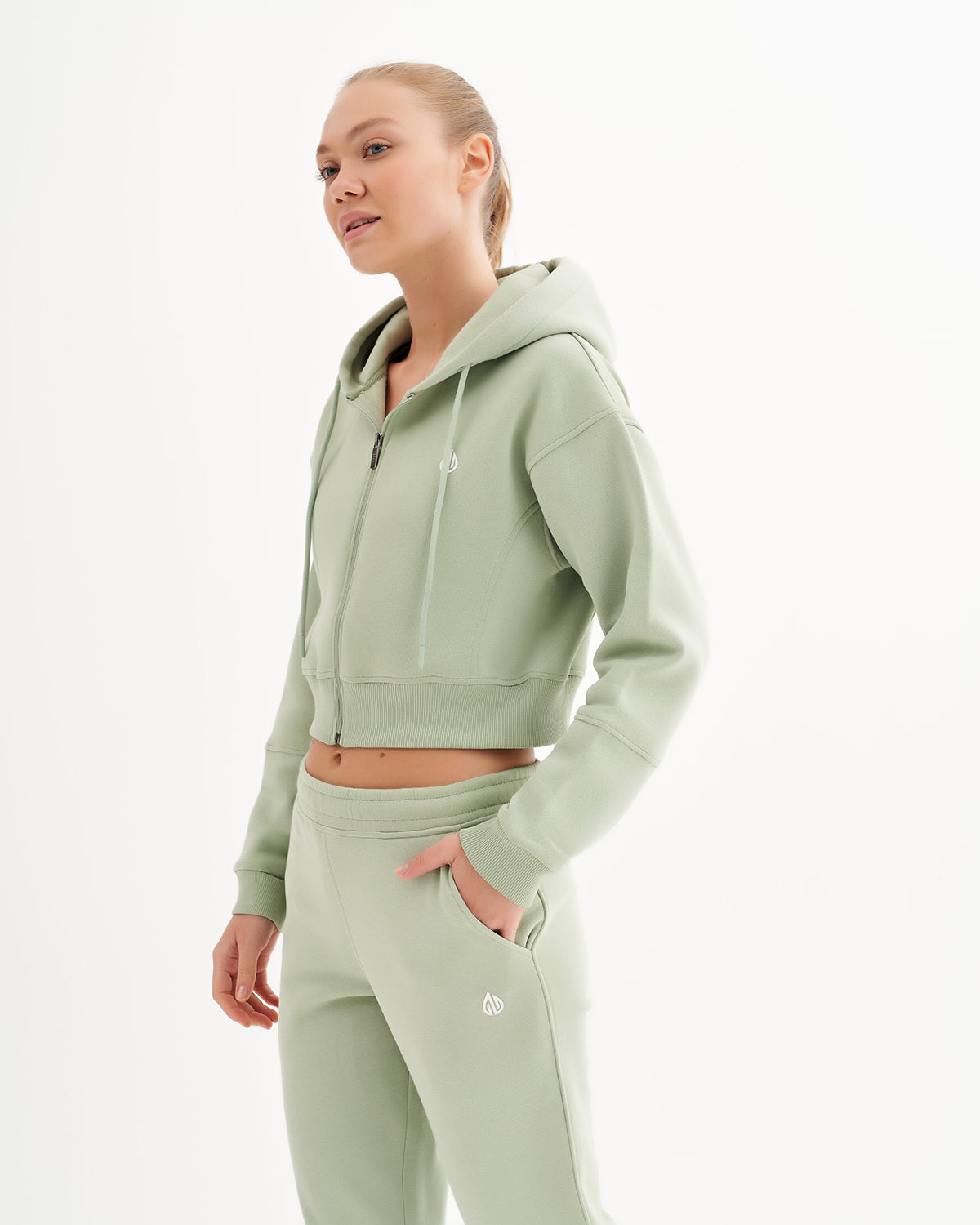 a woman in a light green sweatshirt and sweatpants