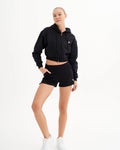 a woman in a black hoodie and shorts