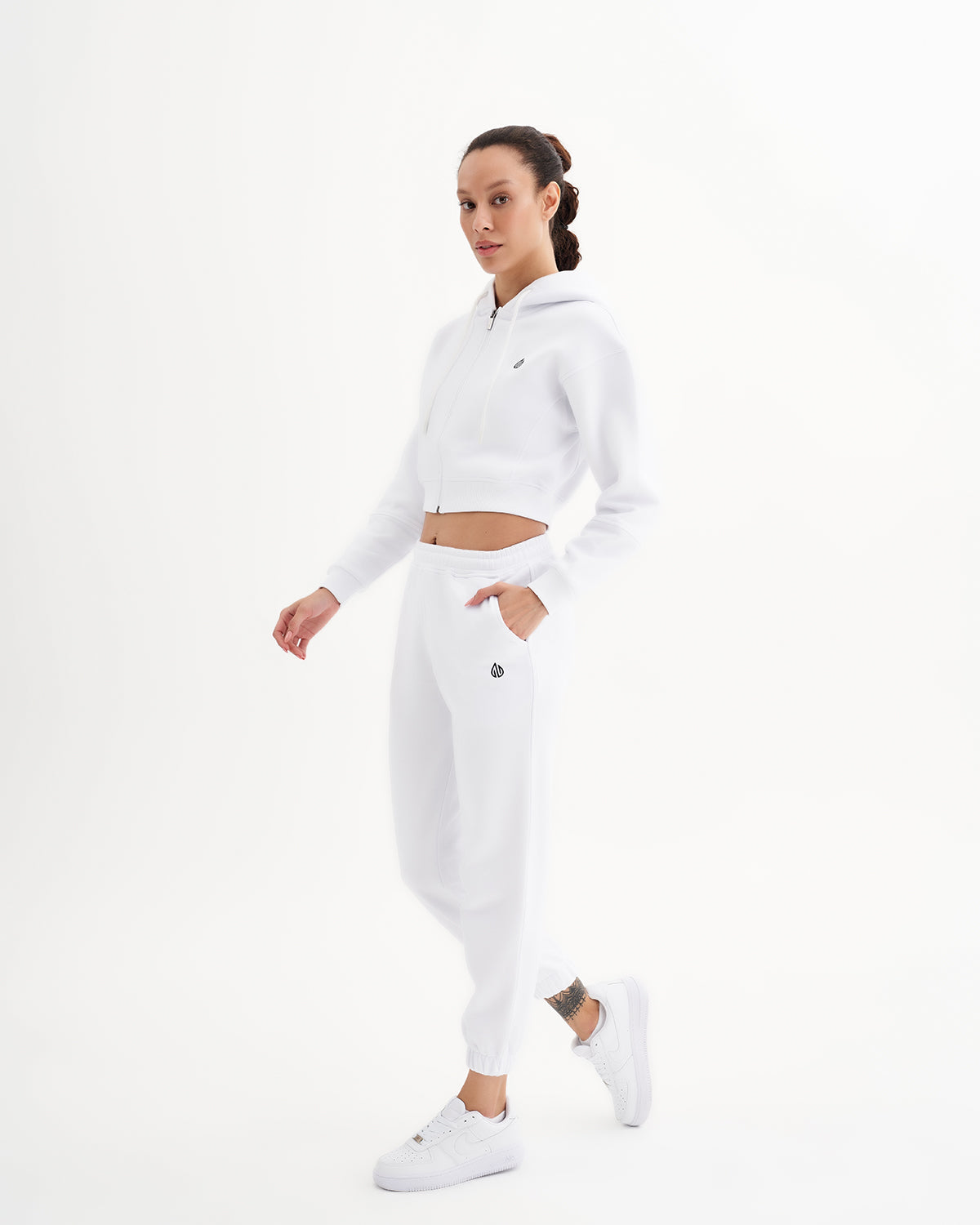 a woman in a white crop top and sweatpants