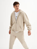 a man in a beige hoodie and sweatpants