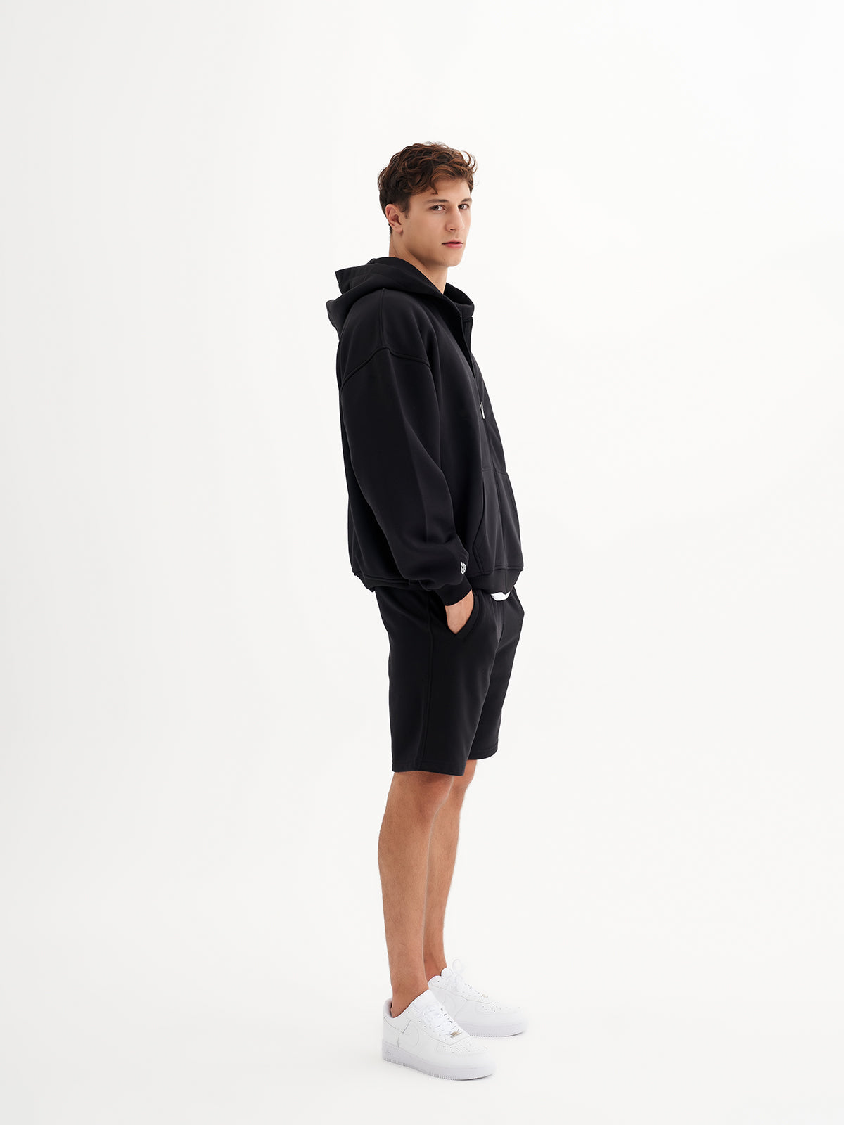 a man in a black hoodie and shorts