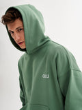 a young man wearing a green hoodie with the word ouu on it