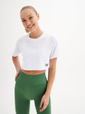 a woman wearing a white crop top and green leggings