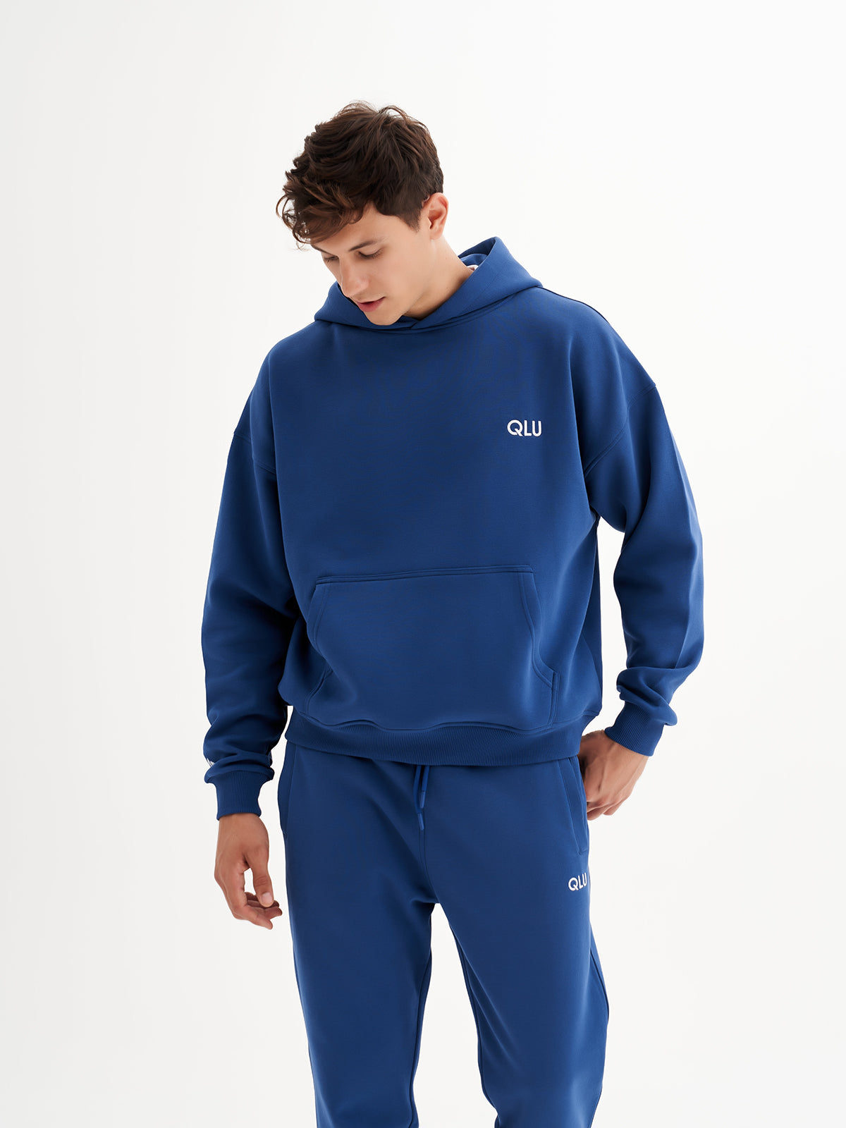 a young man in a blue hoodie and sweatpants