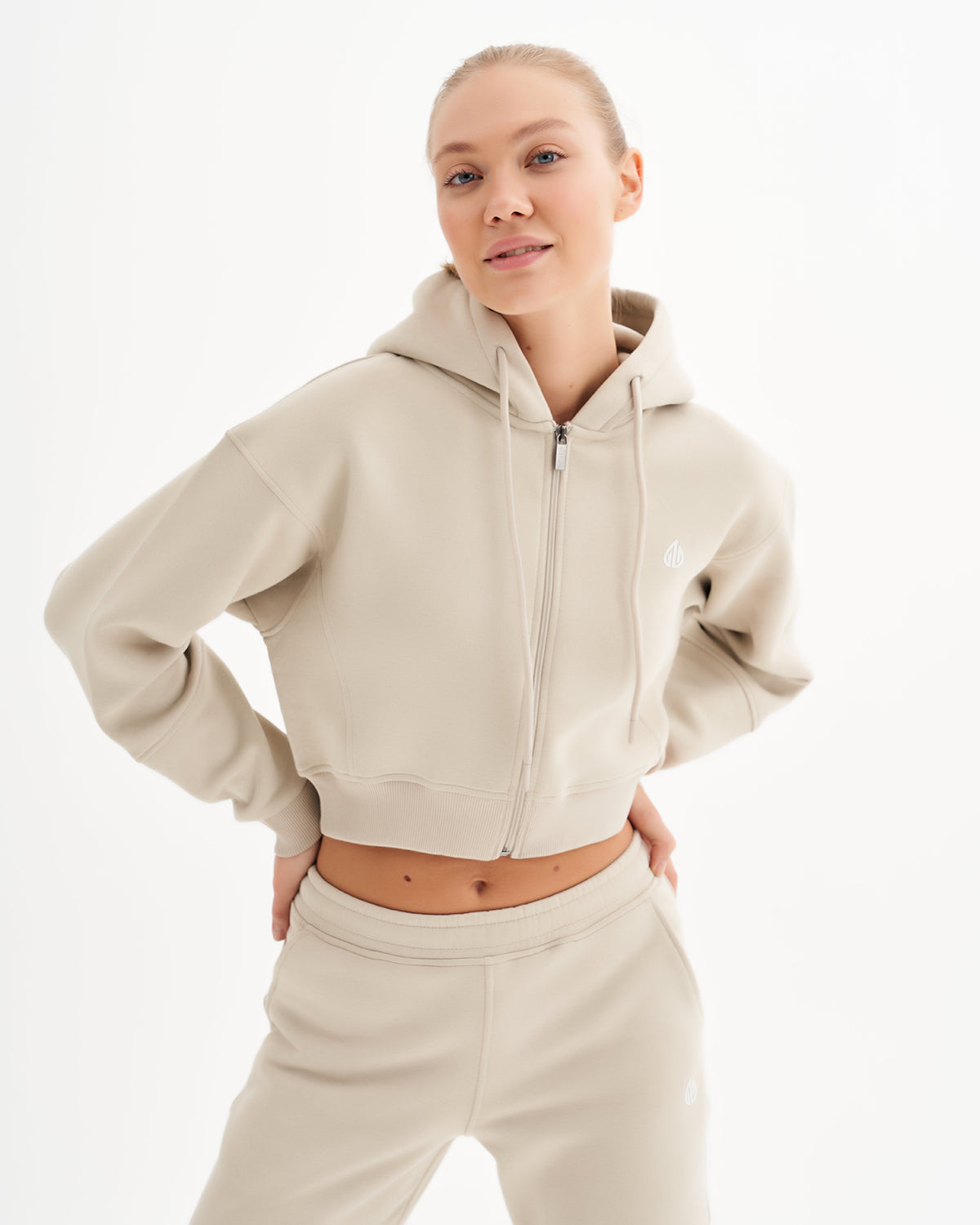 a woman in a beige sweatshirt and pants