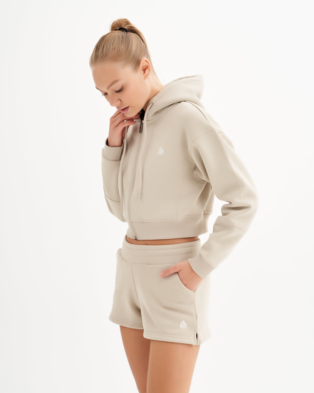 a woman in a beige sweatshirt and shorts