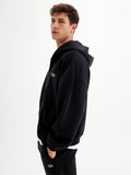 a young man in a black hoodie poses for a picture