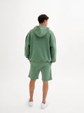 a man in a green sweatshirt and shorts