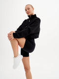 a woman in a black sweatshirt and shorts posing for a picture