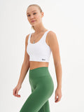 a woman in a white top and green leggings