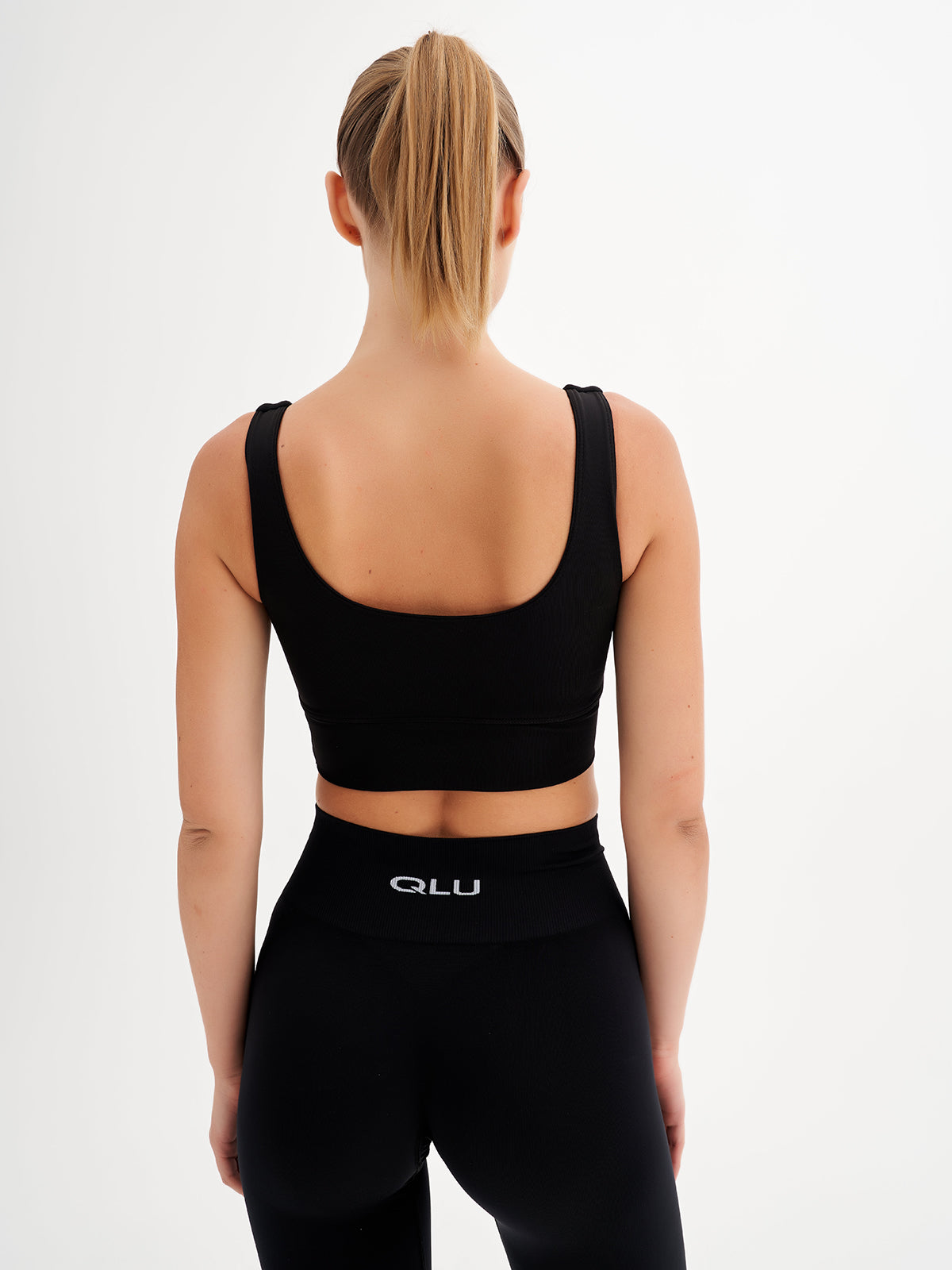 the back of a woman wearing a black sports bra top