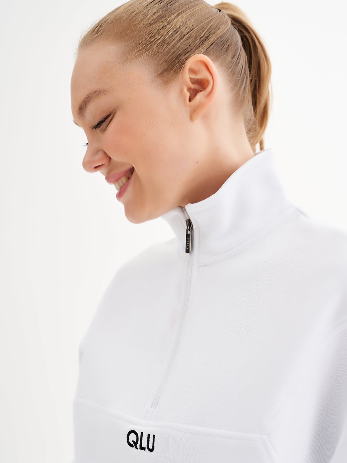 a woman wearing a white jacket and smiling