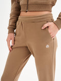 a woman in a brown sweatshirt and pants