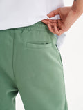 a person wearing a white shirt and green pants