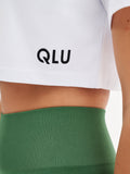 a close up of a person wearing a white shirt and green shorts