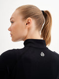 a woman with a ponytail wearing a black top