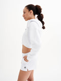 a woman in a white sweatshirt and shorts